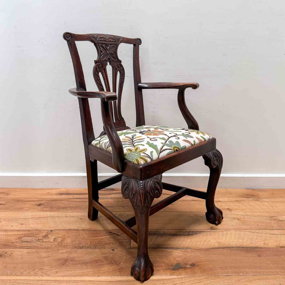 A dark carved oak armchair with cabriole legs, ball and claw feet, a carved splat back, and a crewelwork embroidered seat pad. View VIII