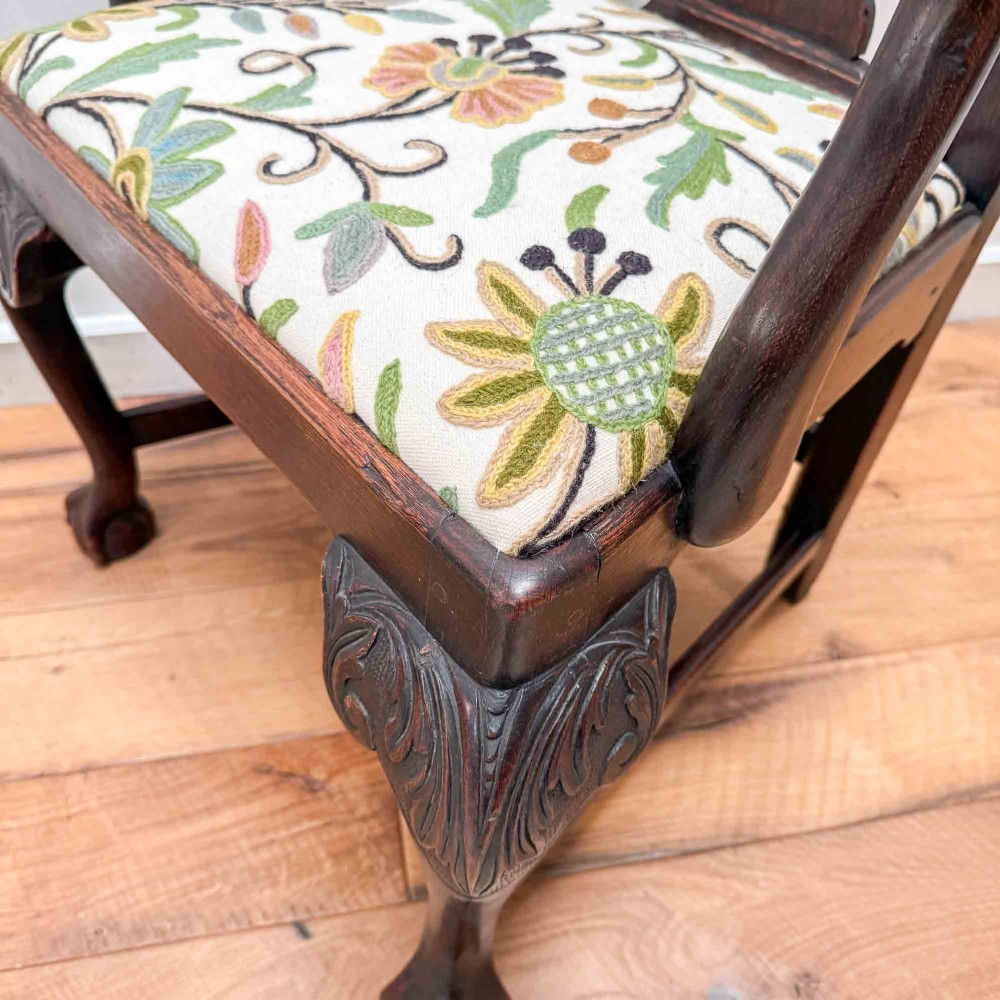 A dark carved oak armchair with cabriole legs, ball and claw feet, a carved splat back, and a crewelwork embroidered seat pad. View XII