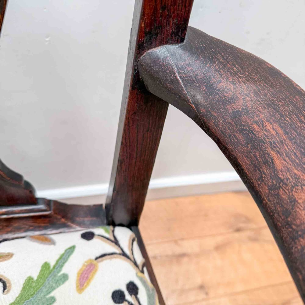 A dark carved oak armchair with cabriole legs, ball and claw feet, a carved splat back, and a crewelwork embroidered seat pad. View XIV