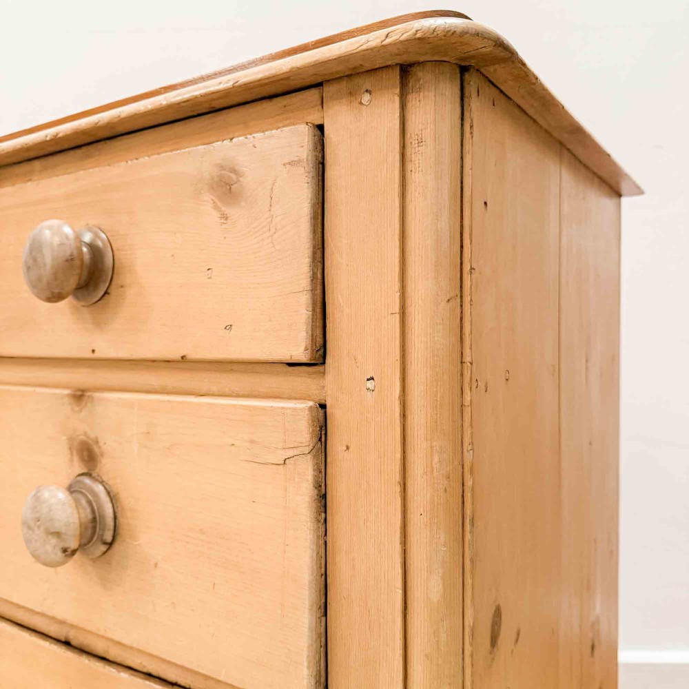 A natural light pine chest of drawers featuring three full-width drawers with turned wooden knobs, rounded front column edges, and turned bun feet. View IV