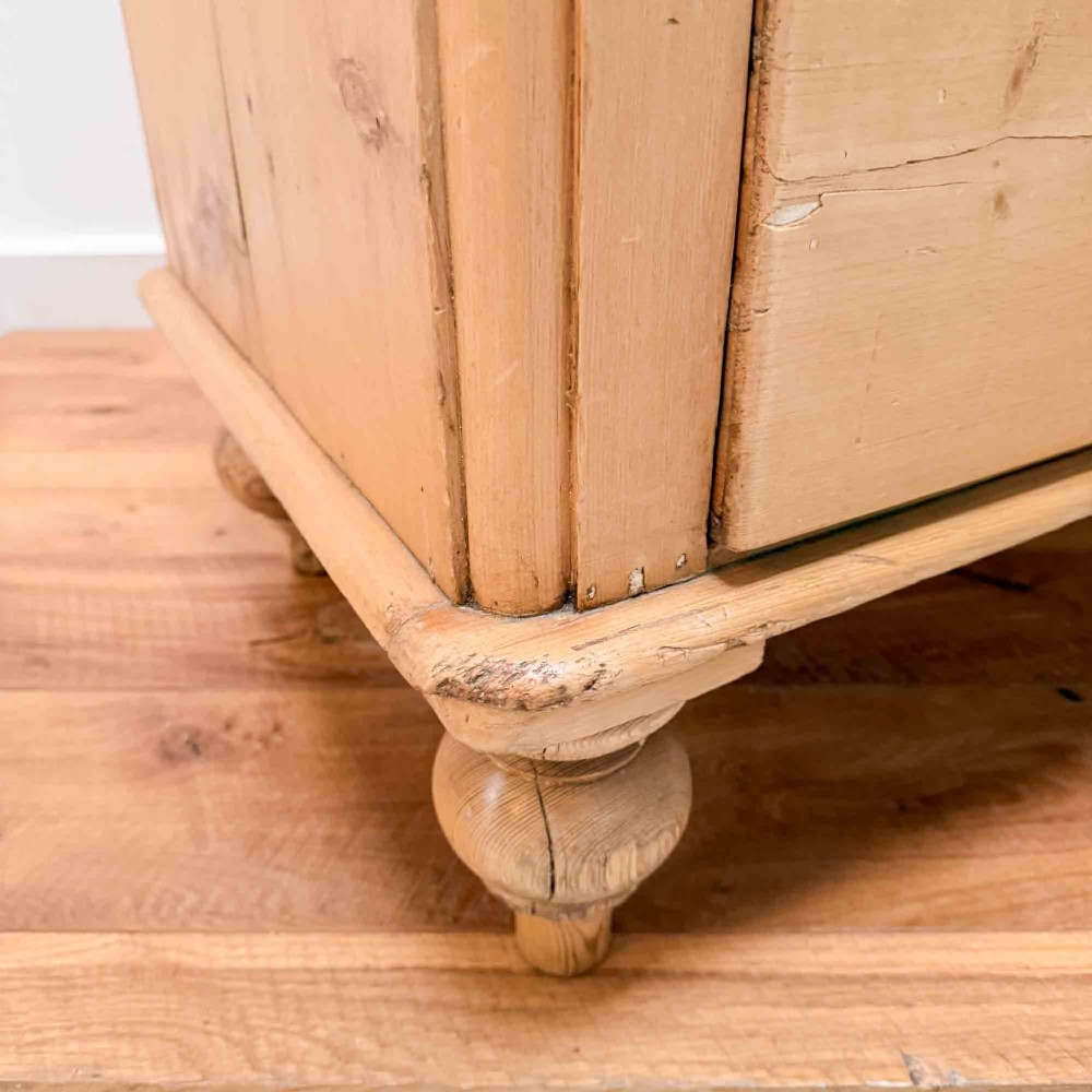 A natural light pine chest of drawers featuring three full-width drawers with turned wooden knobs, rounded front column edges, and turned bun feet. View VIII