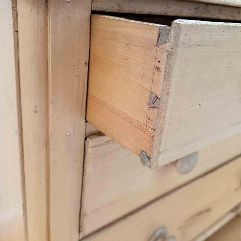 A natural light pine chest of drawers featuring three full-width drawers with turned wooden knobs, rounded front column edges, and turned bun feet. View XII