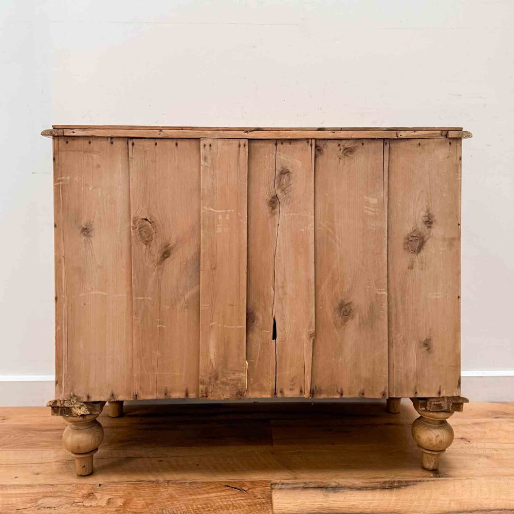 A natural light pine chest of drawers featuring three full-width drawers with turned wooden knobs, rounded front column edges, and turned bun feet. View XIV