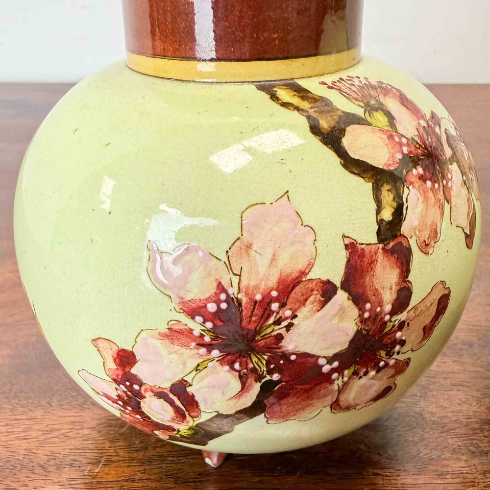 A pair of round pale green ceramic vases with hand-painted pink cherry blossom branches, dark brown collars, and small tripod feet. View VII