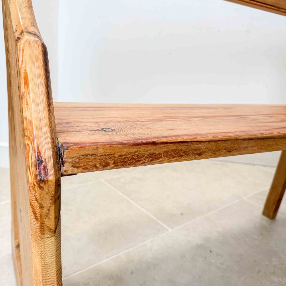 An antique pitch pine open back church pew featuring shaped side supports and a single central back support. View V