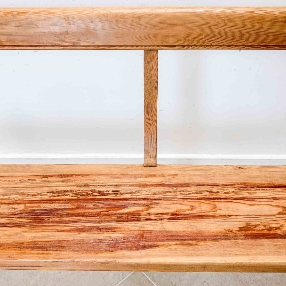 An antique pitch pine open back church pew featuring shaped side supports and a single central back support. View VII