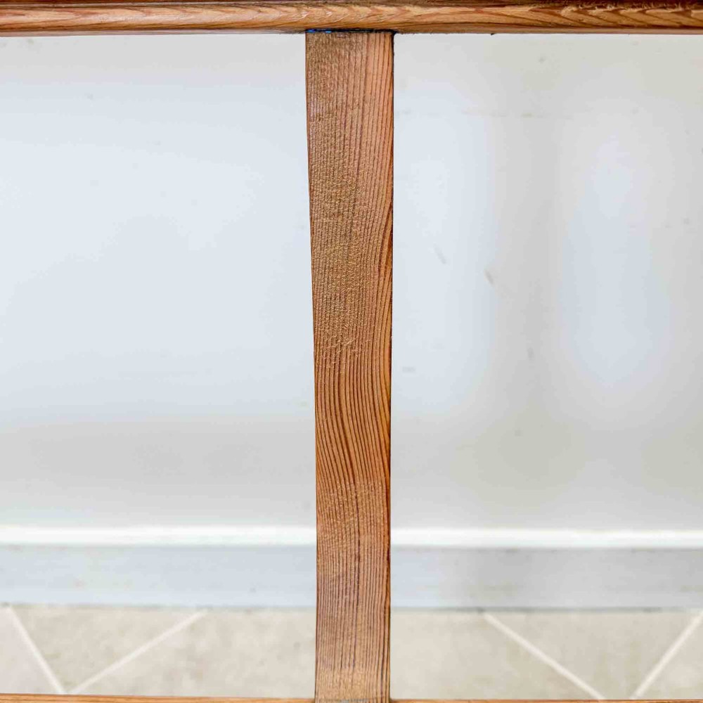 An antique pitch pine open back church pew featuring shaped side supports and a single central back support. View VIII