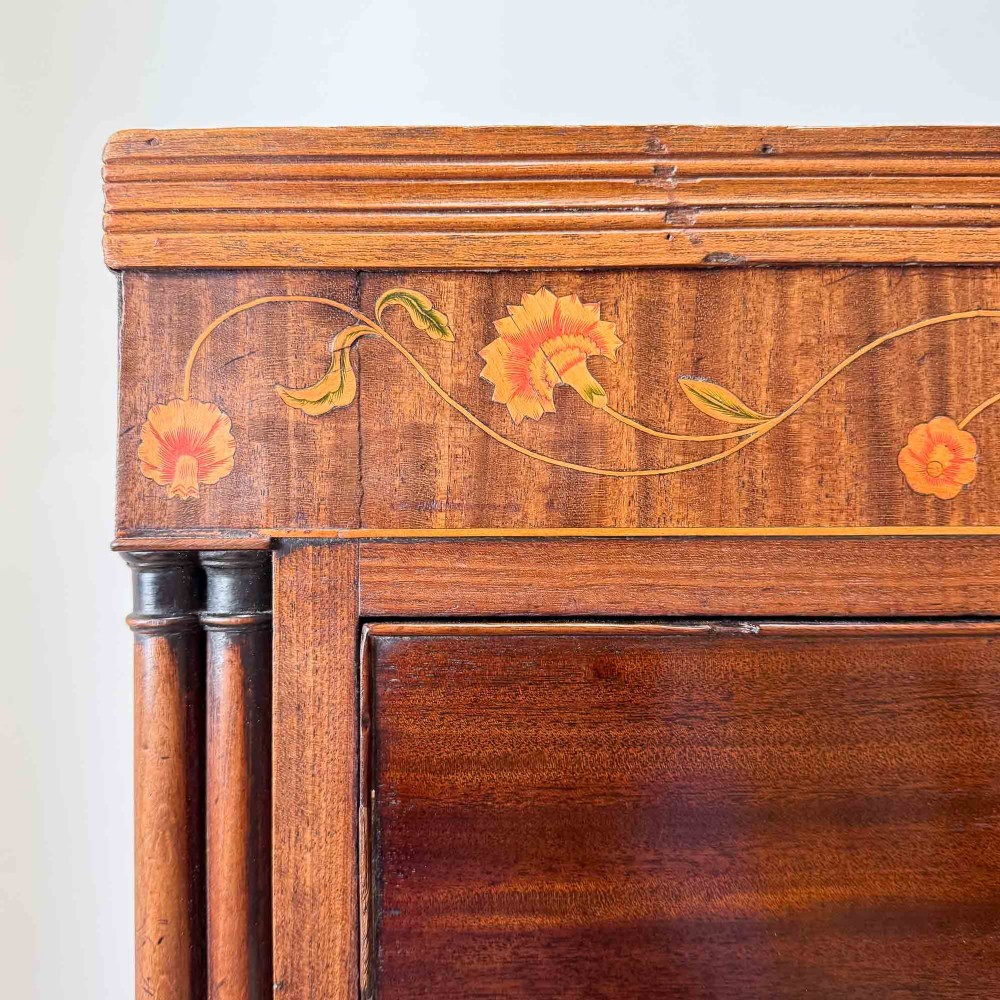An antique mahogany chest of drawers with two short over three long drawers and floral inlay details along the upper frieze. View III