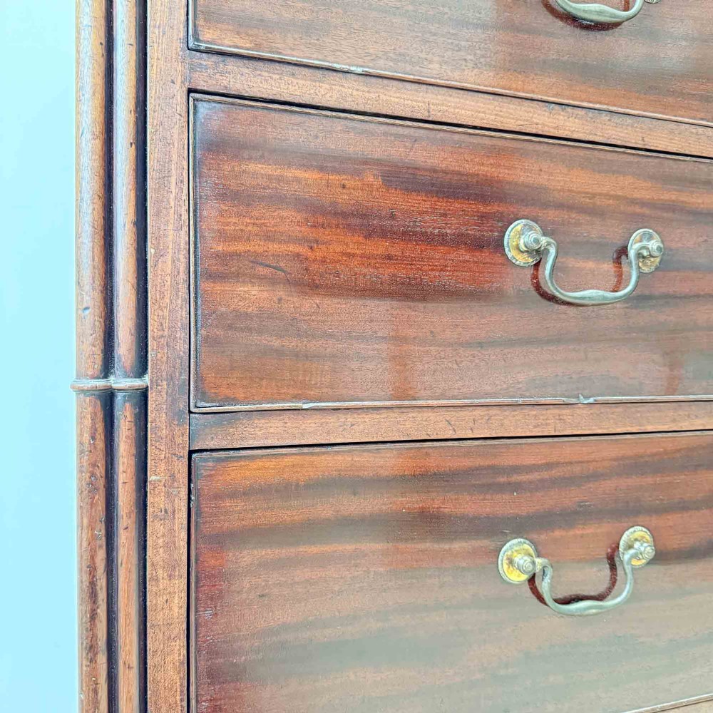 An antique mahogany chest of drawers with two short over three long drawers and floral inlay details along the upper frieze. View X
