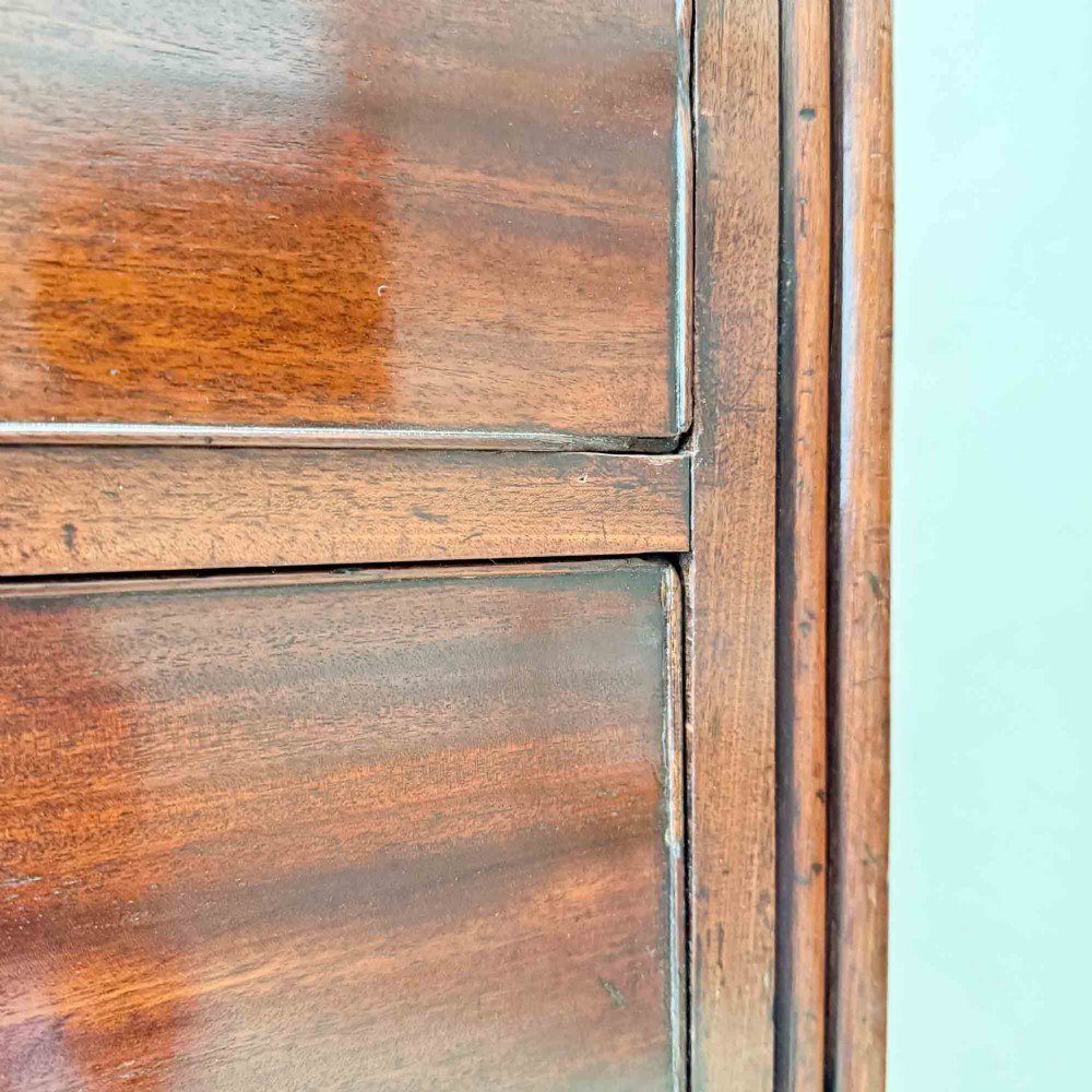 An antique mahogany chest of drawers with two short over three long drawers and floral inlay details along the upper frieze. View XII