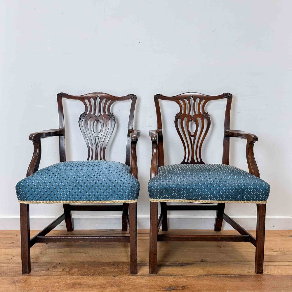 A pair of dark mahogany armchairs featuring carved pierced back splats, shaped arms, and blue patterned upholstered seats. View II