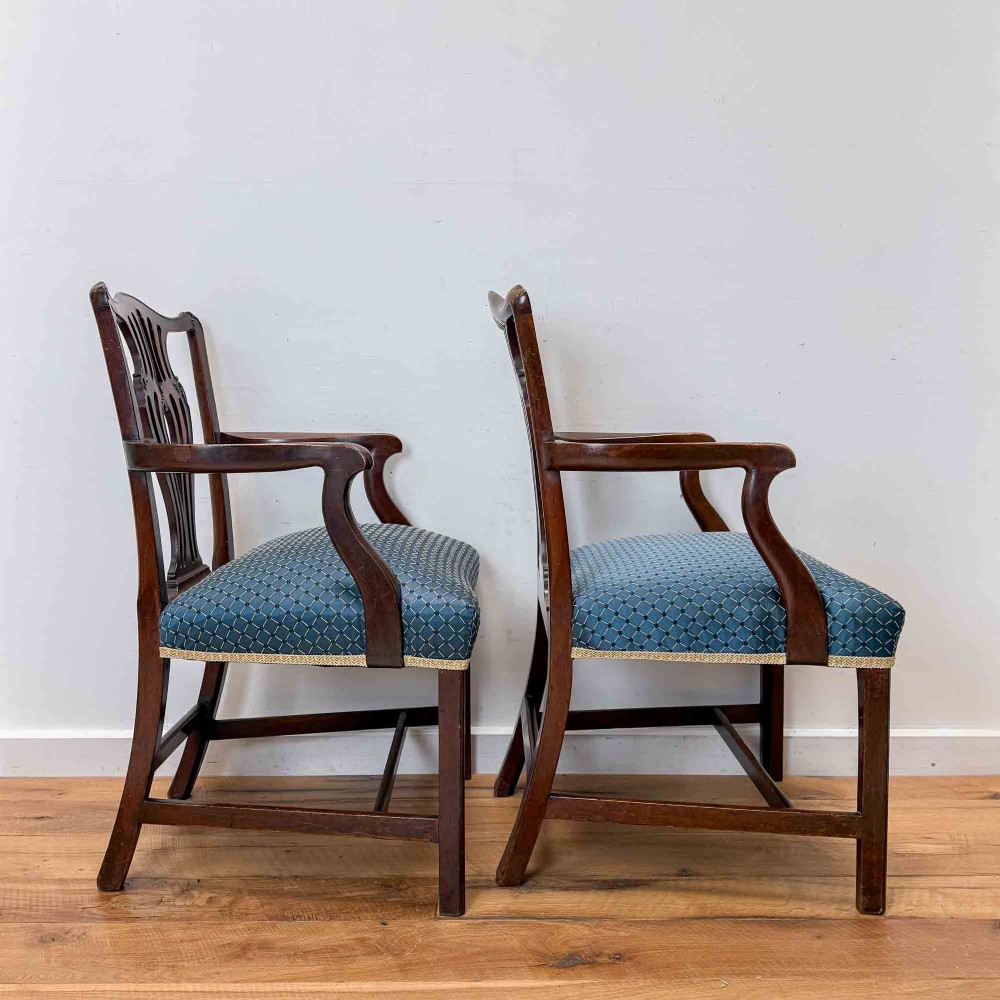 A pair of dark mahogany armchairs featuring carved pierced back splats, shaped arms, and blue patterned upholstered seats. View III