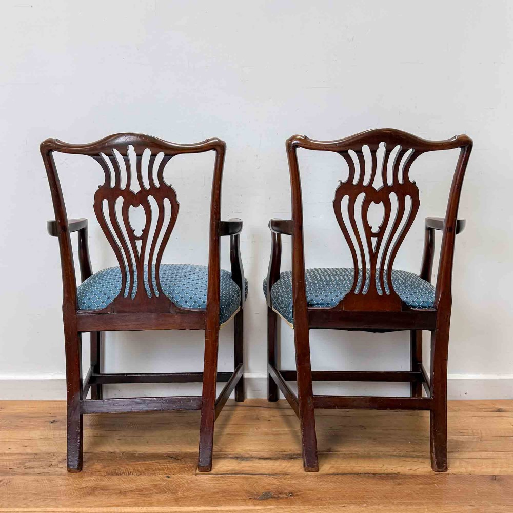 A pair of dark mahogany armchairs featuring carved pierced back splats, shaped arms, and blue patterned upholstered seats. View IV