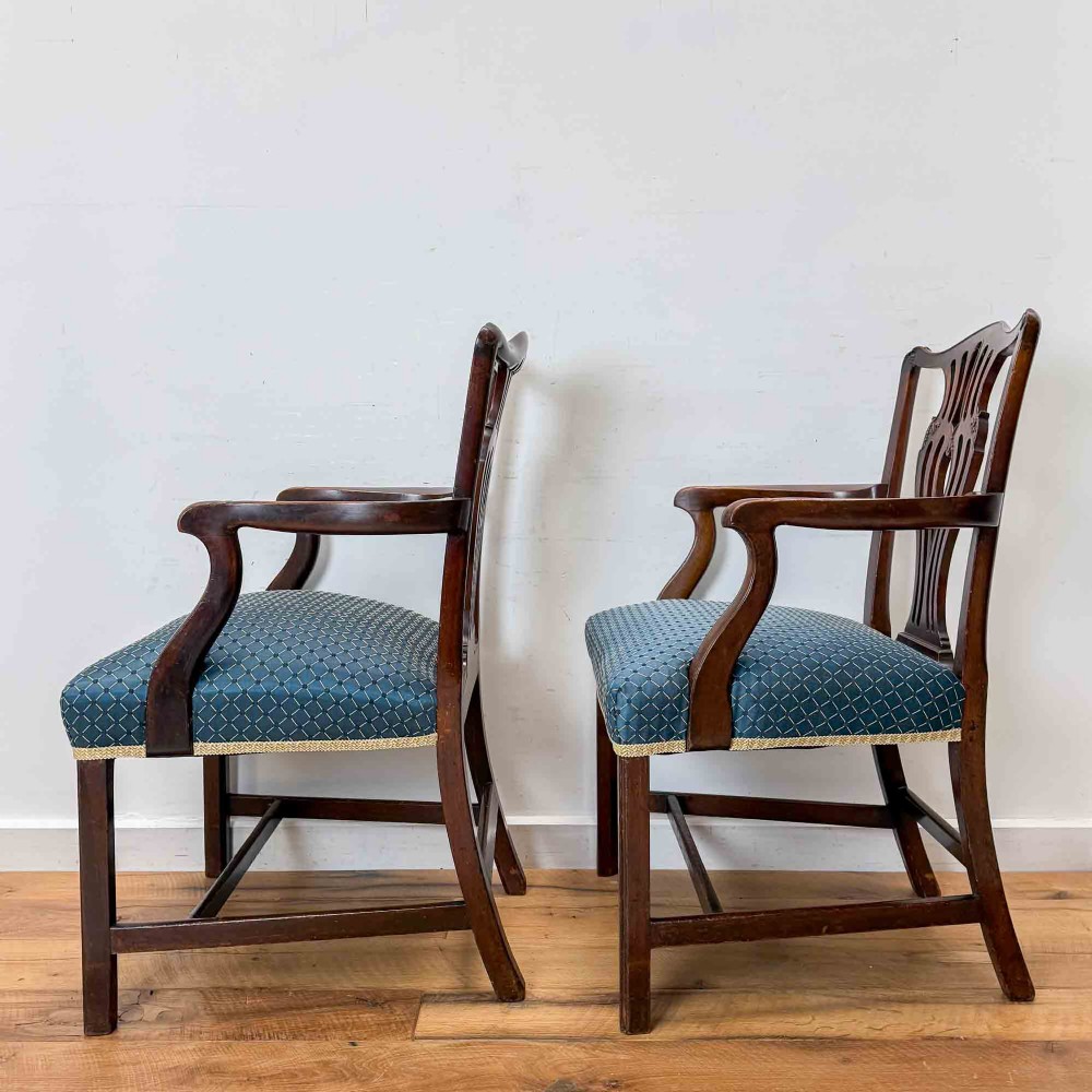 A pair of dark mahogany armchairs featuring carved pierced back splats, shaped arms, and blue patterned upholstered seats. View V