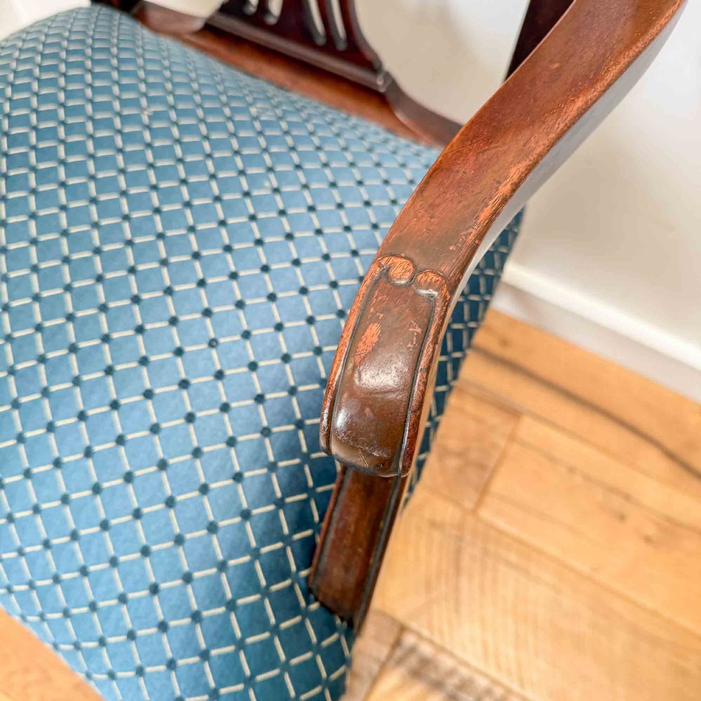 A pair of dark mahogany armchairs featuring carved pierced back splats, shaped arms, and blue patterned upholstered seats. View VI