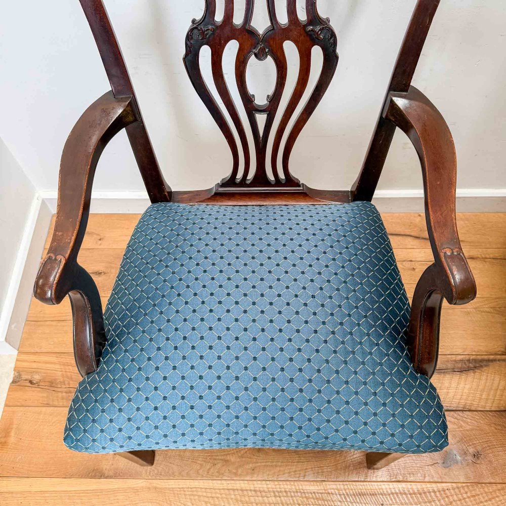 A pair of dark mahogany armchairs featuring carved pierced back splats, shaped arms, and blue patterned upholstered seats. View VIII