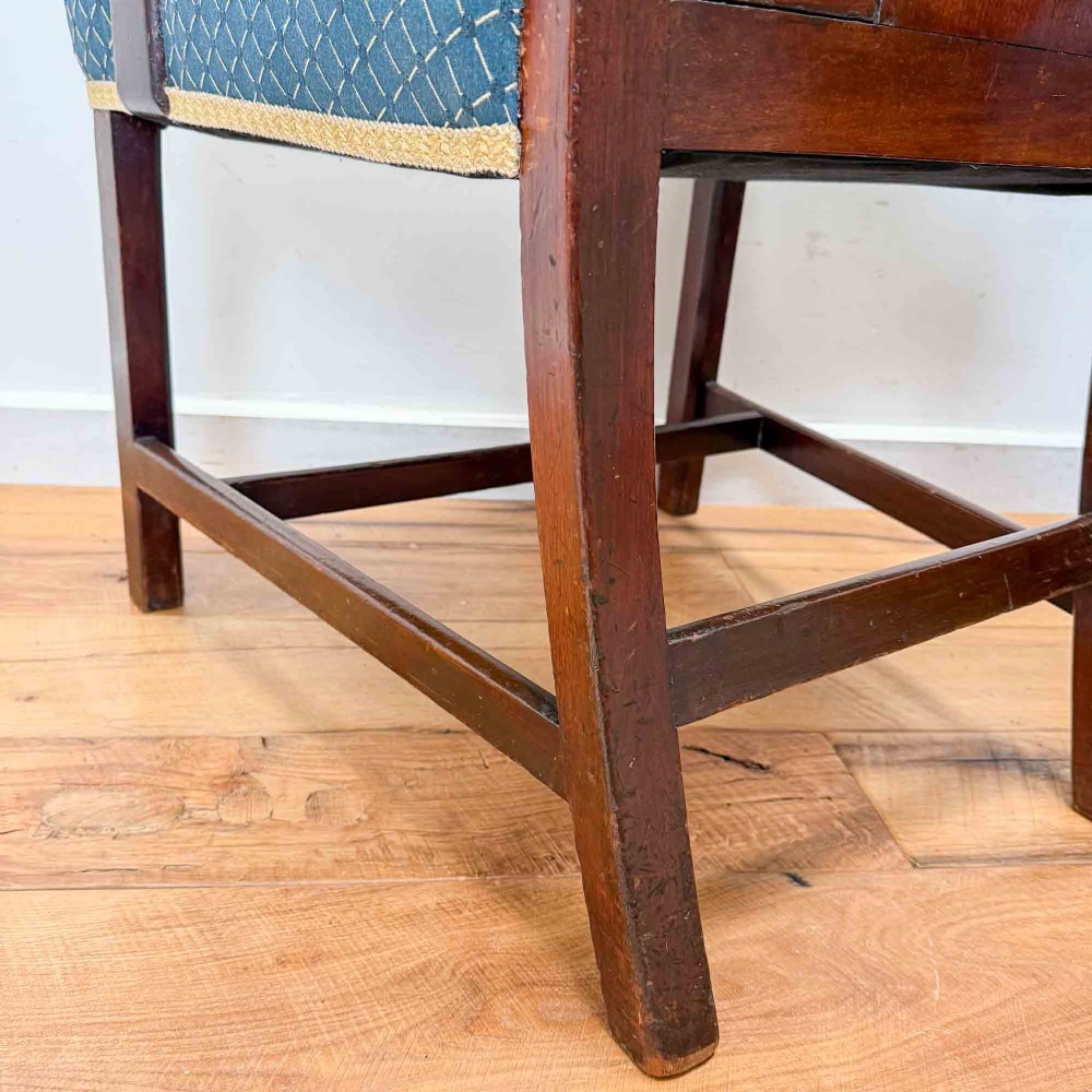 A pair of dark mahogany armchairs featuring carved pierced back splats, shaped arms, and blue patterned upholstered seats. View X
