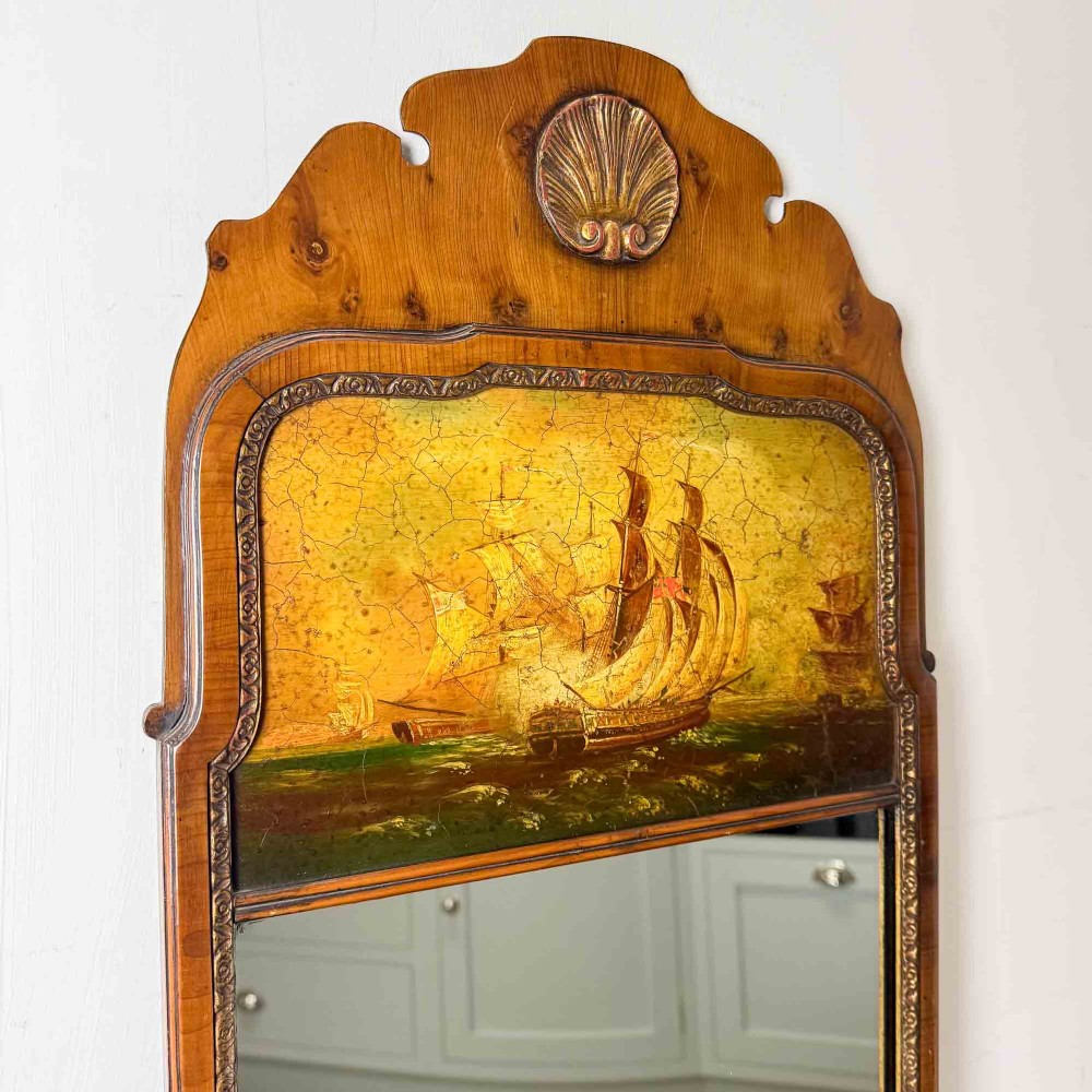 A tall Queen Anne Revival yew wood wall mirror featuring a carved shell crest at the top, an upper panel painted with a sailing ship maritime scene, and a rectangular glass mirror below. View II