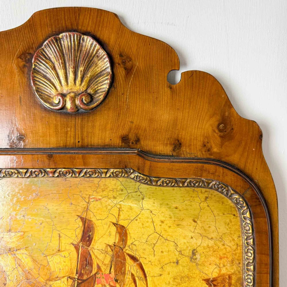 A tall Queen Anne Revival yew wood wall mirror featuring a carved shell crest at the top, an upper panel painted with a sailing ship maritime scene, and a rectangular glass mirror below. View VIII