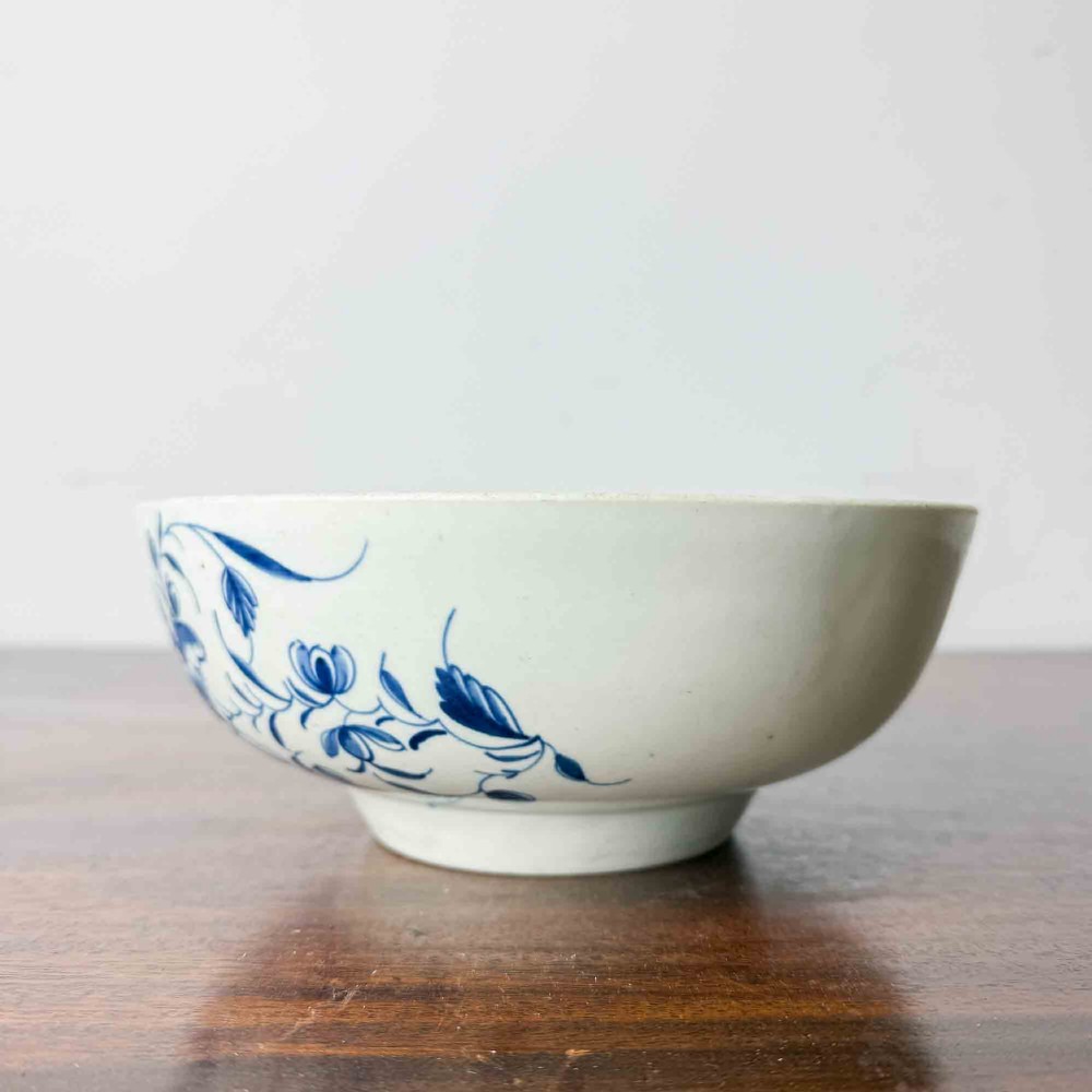 An 18th-century circular soft-paste porcelain bowl featuring hand-painted cobalt blue floral motifs on a white background. View III