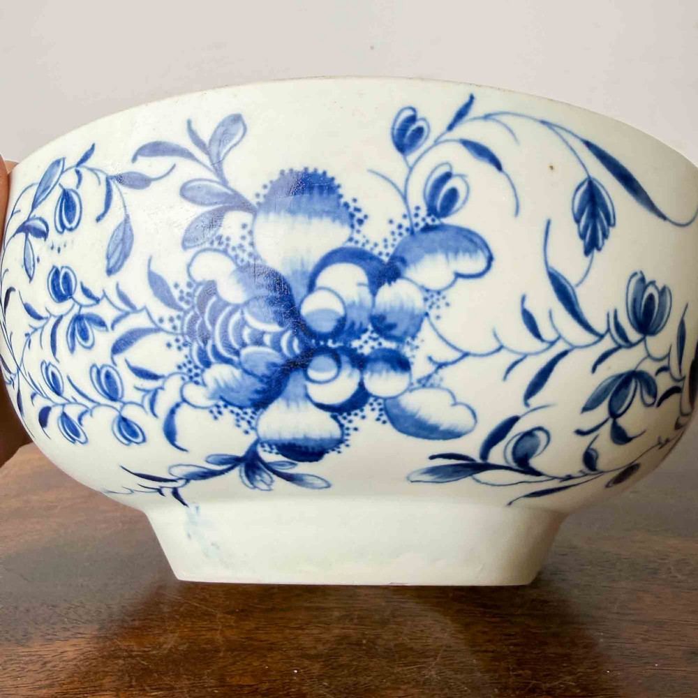 An 18th-century circular soft-paste porcelain bowl featuring hand-painted cobalt blue floral motifs on a white background. View VI