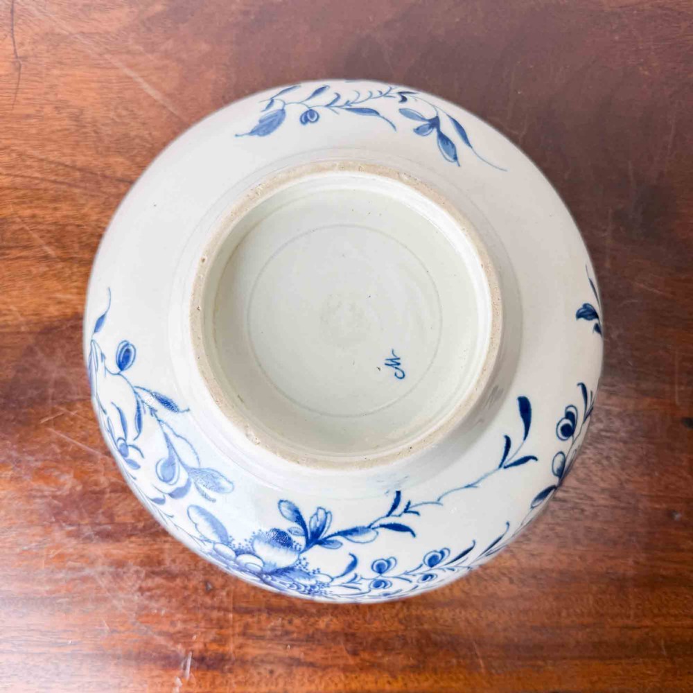 An 18th-century circular soft-paste porcelain bowl featuring hand-painted cobalt blue floral motifs on a white background. View VIII