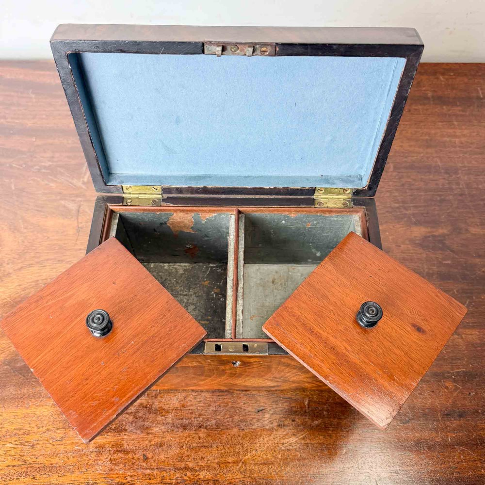 A rectangular early Victorian tea caddy crafted from flame mahogany veneer with crossbanded inlaid borders and a central metal keyhole escutcheon. View XIII