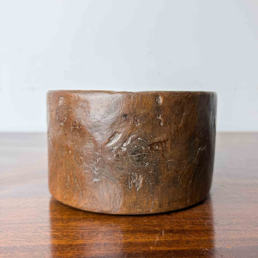A round hand-carved antique wooden bowl with thick walls and a patinated brown timber surface. View VIII