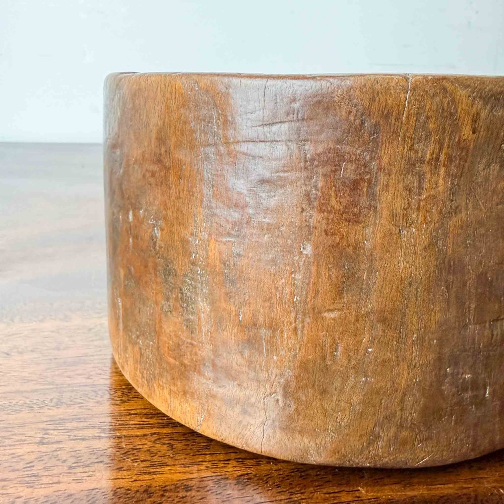 A round hand-carved antique wooden bowl with thick walls and a patinated brown timber surface. View IX