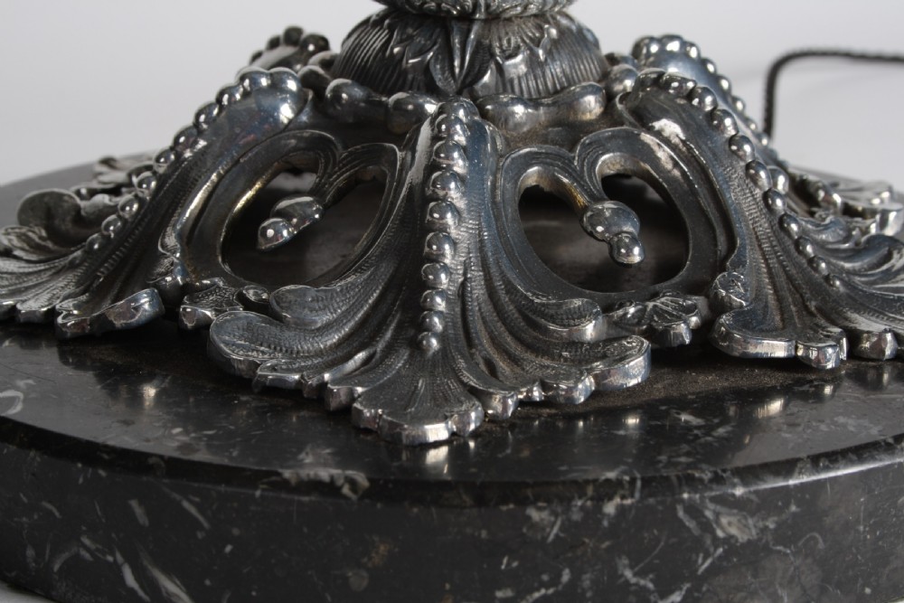 A polished silver-toned spelter table lamp base in the shape of a classical urn with relief carvings and creature handles on a circular marble plinth. View XIV