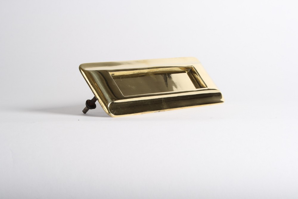 A solid polished brass Art Deco letterbox plate featuring a central rectangular flap within a streamlined bevelled frame. View III