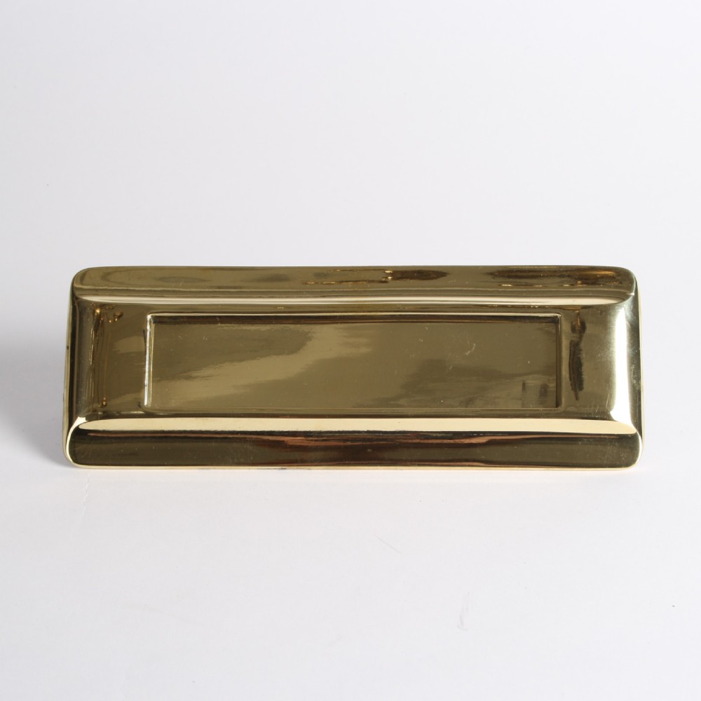 A solid polished brass Art Deco letterbox plate featuring a central rectangular flap within a streamlined bevelled frame. View VII