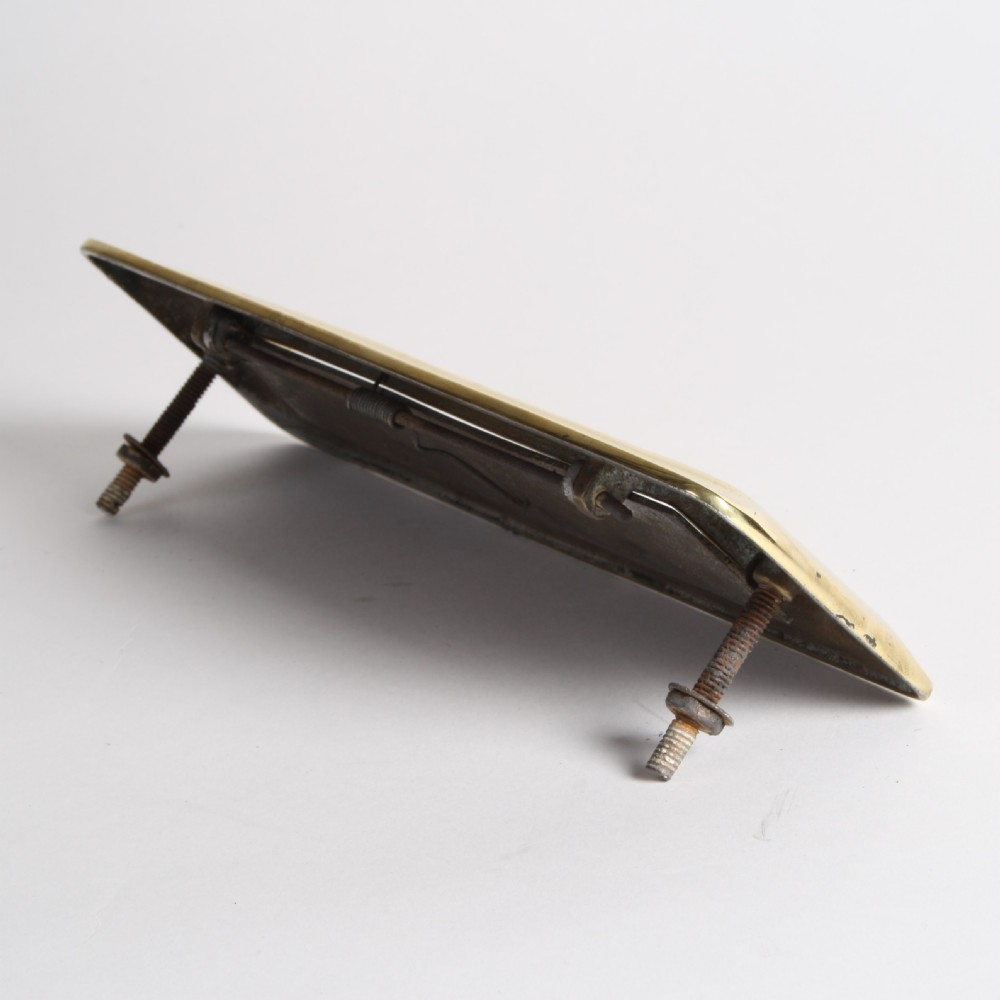 A solid polished brass Art Deco letterbox plate featuring a central rectangular flap within a streamlined bevelled frame. View IX