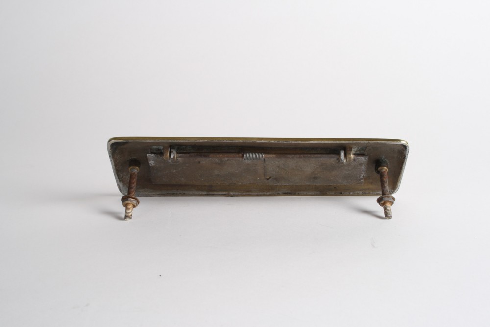 A solid polished brass Art Deco letterbox plate featuring a central rectangular flap within a streamlined bevelled frame. View XII