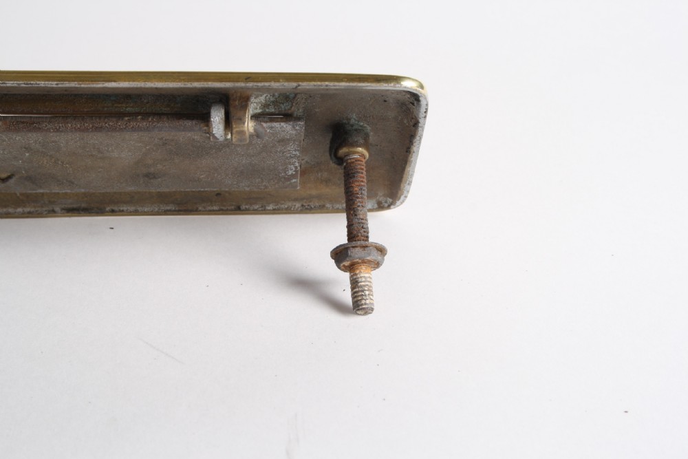 A solid polished brass Art Deco letterbox plate featuring a central rectangular flap within a streamlined bevelled frame. View XIII