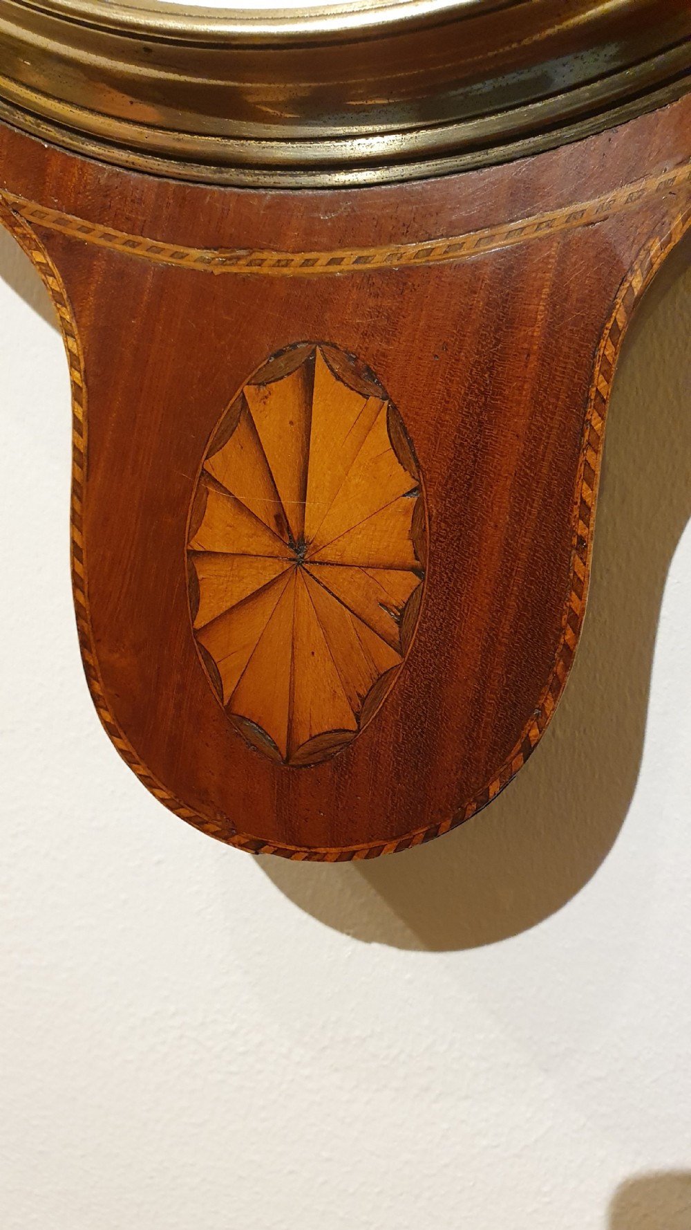 An antique mahogany wheel barometer featuring a banjo-shaped wooden casing with an upper vertical thermometer scale and a lower circular dial. View II