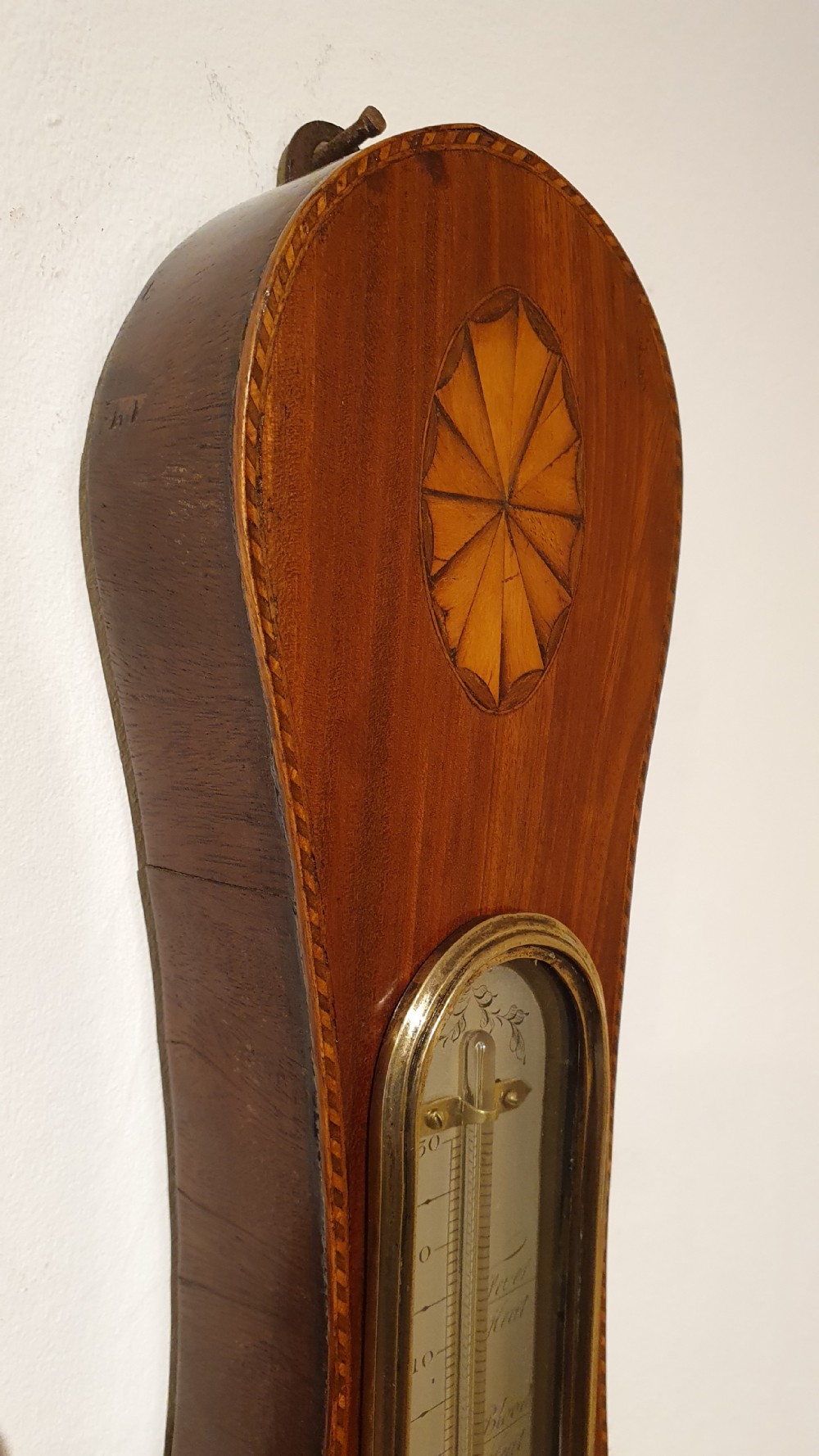 An antique mahogany wheel barometer featuring a banjo-shaped wooden casing with an upper vertical thermometer scale and a lower circular dial. View V