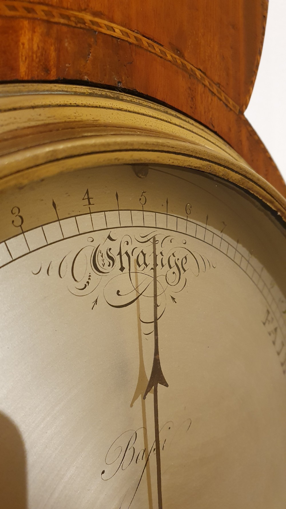 An antique mahogany wheel barometer featuring a banjo-shaped wooden casing with an upper vertical thermometer scale and a lower circular dial. View VI