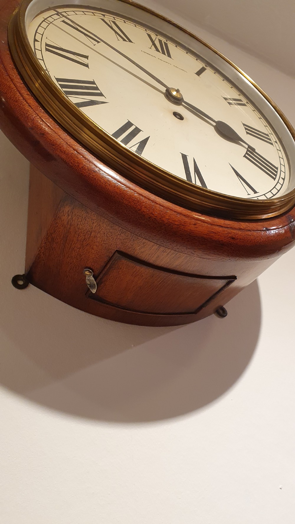 A circular antique mahogany wall clock featuring an off-white dial with black Roman numerals, black hands, and London County Council text. View II