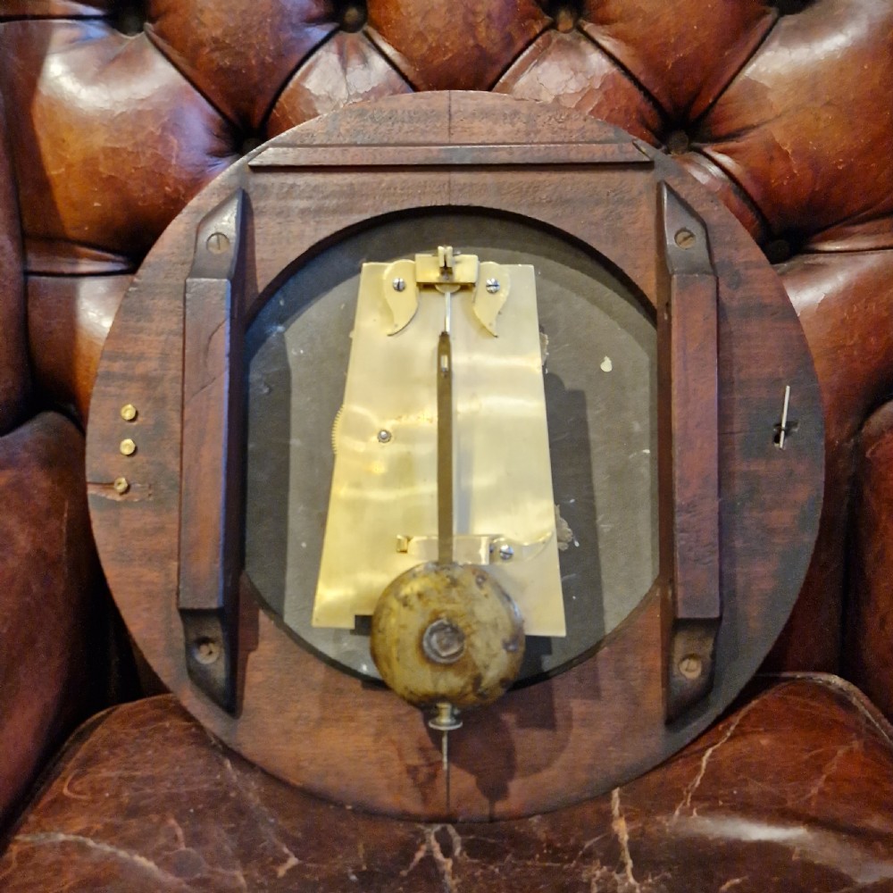 An antique circular fusee wall clock featuring a dark mahogany surround, brass bezel, and a white dial with Roman numerals signed Richd Clark Newport. View II