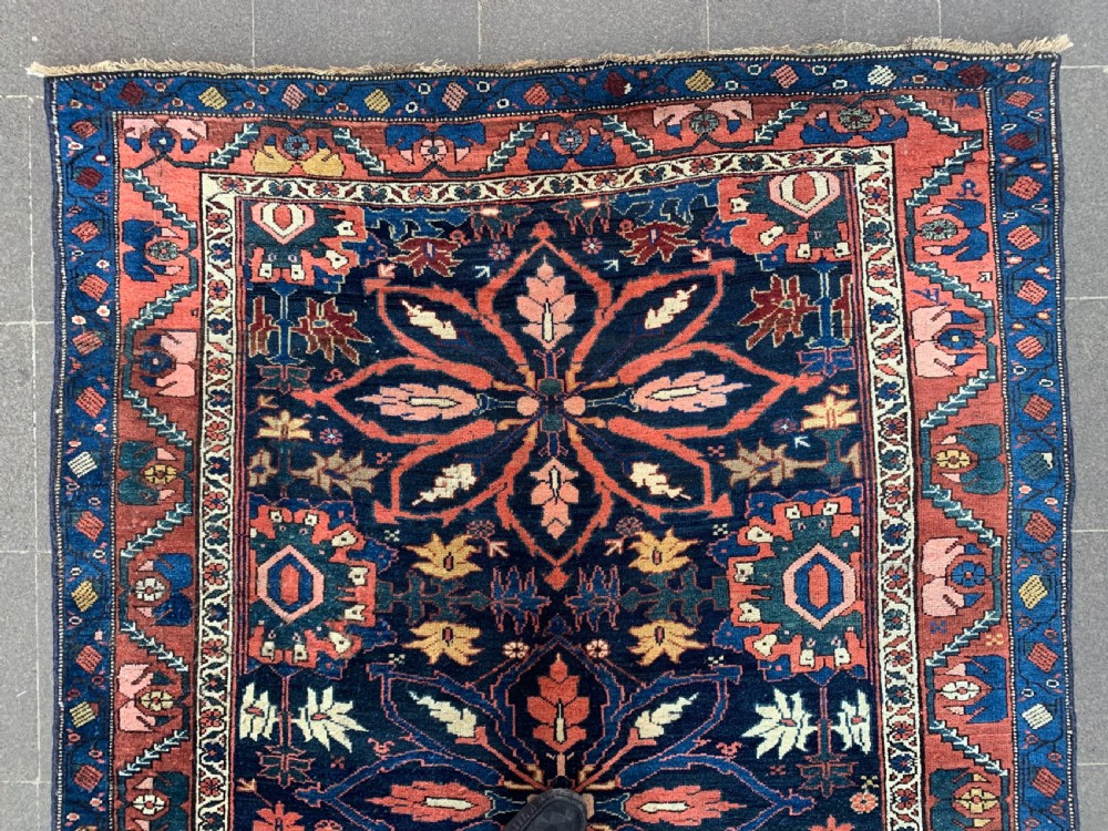 An antique hand-knotted Persian Bidjar long rug featuring a central column of large star rosettes on a navy blue field enclosed within a decorated terracotta border. View V