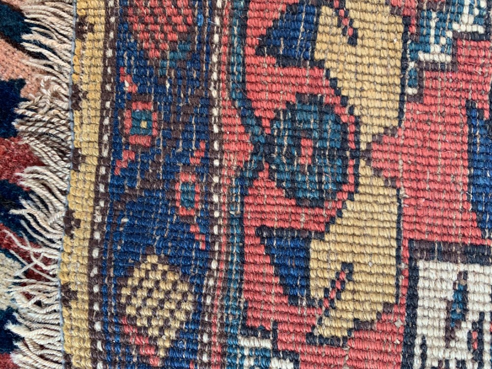 An antique hand-knotted Persian Bidjar long rug featuring a central column of large star rosettes on a navy blue field enclosed within a decorated terracotta border. View VIII