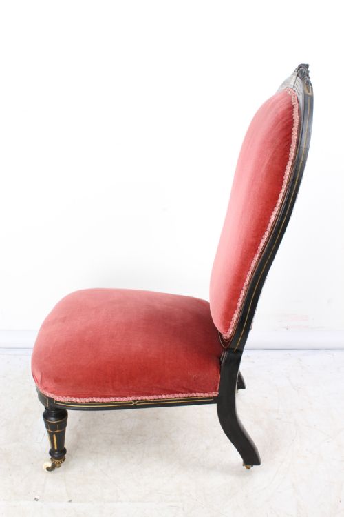 fig 1. A Victorian Aesthetic Movement dressing table chair featuring an ebonised wooden frame with gilt line decoration, upholstered in rose pink velvet on castors.
