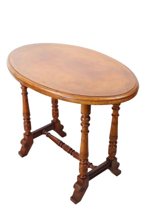 fig 1. A small Victorian mahogany side table featuring an oval top, four turned support legs, a turned central stretcher, and shaped feet.