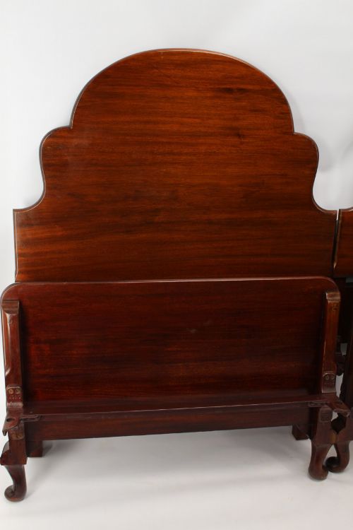 fig 2. A matching pair of Art Deco mahogany single beds with stepped, arched headboards and low footboards on short cabriole feet.