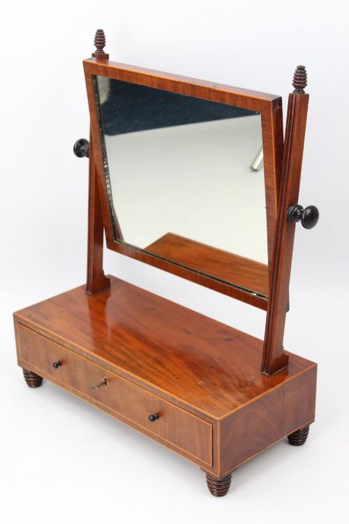 fig 1. An antique Regency mahogany toilet mirror featuring an adjustable rectangular mirror set between turned upright posts above a single drawer base.