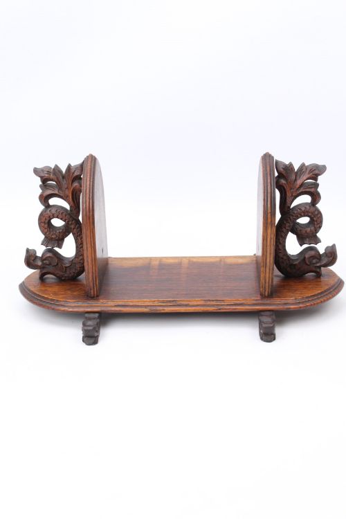 fig 1. A dark oak desktop book stand featuring pointed arch uprights, carved mythical creature side accents, and scroll feet.
