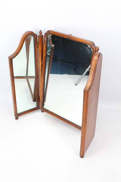 fig 1. A three-panel walnut triptych dressing table mirror featuring arched side wings, turned finials, and brass hinges.