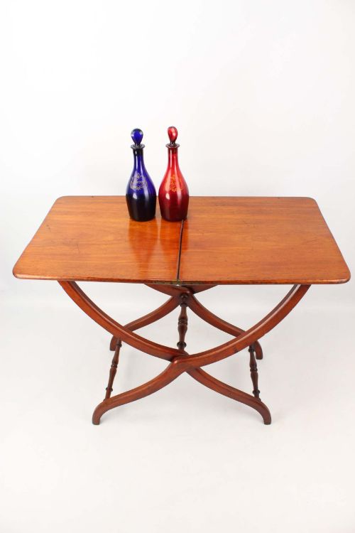 fig 1. A Victorian mahogany coaching table featuring a rectangular folding top supported by curved X-frame legs and turned stretchers.