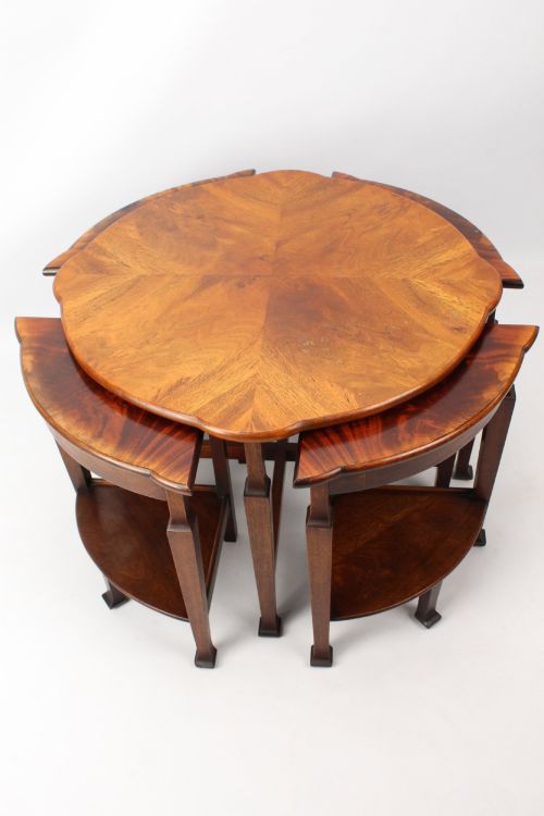 fig 1. An Art Deco warm brown walnut circular coffee table featuring four sector-shaped nesting side tables stowed underneath.